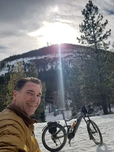 Sun setting over a mountain with Chris and his ebike in front