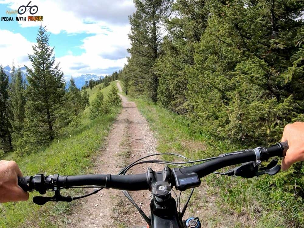 looking down a dirt road from the saddle of an electric bike